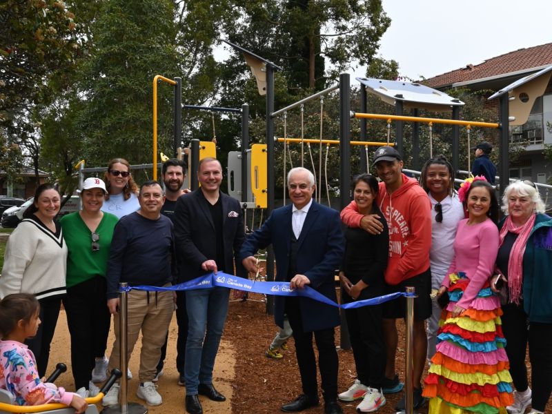 Group of adults cutting the ribbon for a playground opening