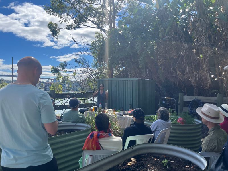 Group of people sitting on chairs watching a gardening demonstration