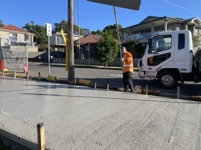 Man smoothing new cement pathway