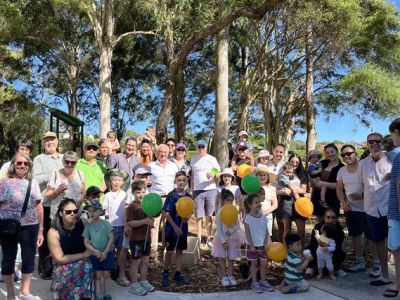 Group of people posing as a group in front of a playground